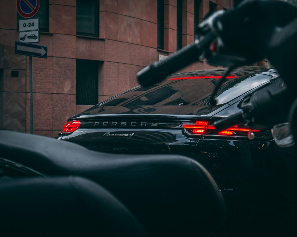 Rear view of a black Porsche Panamera 4 parked in an urban street.